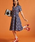 Woman in a retro dress with red roller skates and a boombox on an orange background