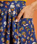 Close up of pocket on colorful patterned fabric skirt with cats and rainbows on a blue background