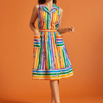 Woman wearing a colorful striped rainbow skirt with matching sleeveless blouse