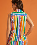 Back view of woman wearing a colorful striped shirt with floral patterns on an orange background