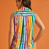 Back view of woman wearing a colorful striped shirt with floral patterns on an orange background