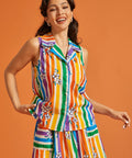 Woman wearing a colorful striped sleeveless cotton summer blouse and matching skirt set