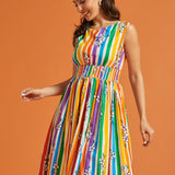 Woman wearing a rainbow stripe pride dress against an orange background