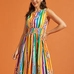 Woman wearing a colorful striped dress against an orange background