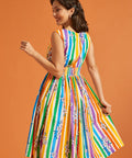 Woman wearing a colorful striped summer dress against an orange background