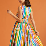 Woman wearing a colorful striped summer dress against an orange background