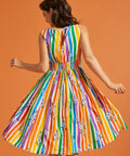 Back view of a woman wearing a colorful rainbow striped dress with a floral pattern on an orange background