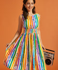 Woman wearing a colorful striped dress holding a boombox against an orange background