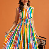 Woman wearing a colorful striped dress holding a boombox against an orange background