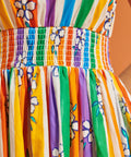 Close up of smocked waistband on a colorful striped dress with floral patterns
