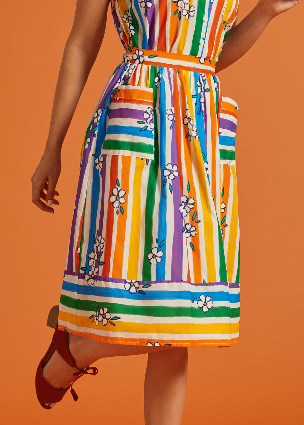 Colorful striped skirt with floral patterns on an orange background