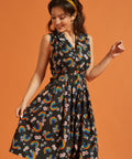 Woman wearing a vintage inspired black dress with rainbow and floral pattern