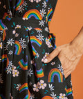 Close up of black dress with rainbow and floral pattern with side pockets