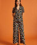 Woman wearing a rainbow floral patterned short sleeve cotton blouse with matching palazzo pants