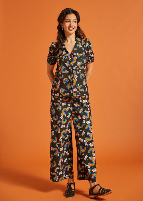 Woman wearing a rainbow floral patterned short sleeve cotton blouse with matching palazzo pants