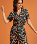 Woman wearing a black shirt and pants with colorful rainbow and floral patterns
