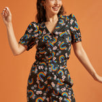 Woman wearing a black shirt and pants with colorful rainbow and floral patterns