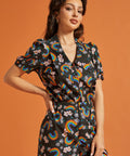Woman wearing a matching two piece outfit with rainbow and floral pattern 