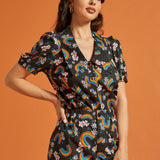 Woman wearing a matching two piece outfit with rainbow and floral pattern 