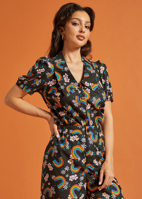 Woman wearing a matching two piece outfit with rainbow and floral pattern 