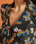 Close-up of a black collared blouse with colorful rainbow and floral patterns