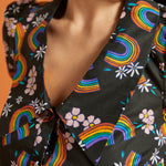 Close-up of a black collared blouse with colorful rainbow and floral patterns