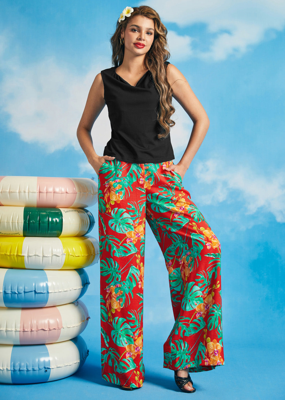Woman wearing a black sleeveless boatneck knit top with tropical print wide-leg pants