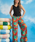 Woman wearing a black sleeveless boatneck knit top with tropical print wide-leg pants