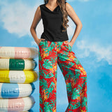 Woman wearing a black sleeveless boatneck knit top with tropical print wide-leg pants