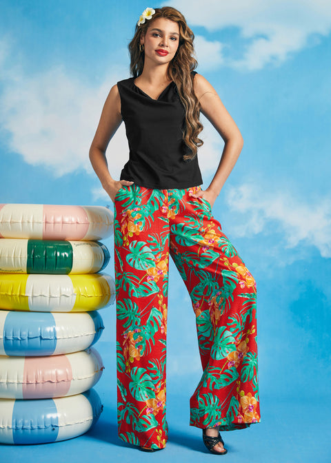 Woman wearing a black sleeveless boatneck knit top with tropical print wide-leg pants