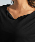 Close-up of the black boatneck neckline and smooth stretch knit fabric