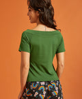 Back view of a woman wearing a green top with short sleeves
