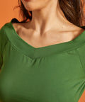 Close-up of the neckline detail on a green blouse