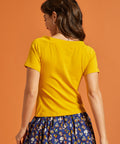 Back view of a woman wearing a solid yellow shirt