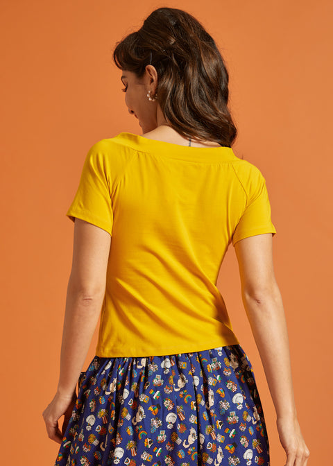 Back view of a woman wearing a solid yellow shirt