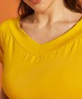 Close-up of the v-neck detail on a yellow blouse