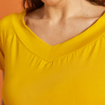 Close-up of the v-neck detail on a yellow blouse