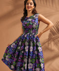 Woman wearing a floral cotton midi dress with fitted smocked waist and full skirt