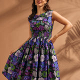 Woman wearing a floral cotton midi dress with fitted smocked waist and full skirt