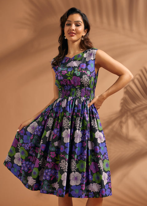 Woman wearing a floral cotton midi dress with fitted smocked waist and full skirt