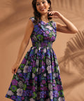 Woman wearing a black floral midi dress with smocked waist and full skirt