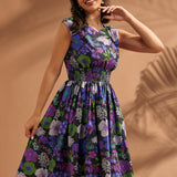 Woman wearing a black floral midi dress with smocked waist and full skirt