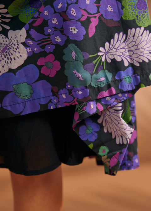 Close-up of colorful purple and green floral print on black cotton dress
