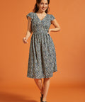 Full-length view of black floral dress with smocked waist and flutter sleeves
