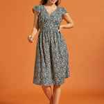 Full-length view of black floral dress with smocked waist and flutter sleeves