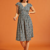 Full-length view of black floral dress with smocked waist and flutter sleeves