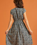 Back view of black floral fit-and-flare dress with gathered waist