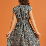 Back view of black floral fit-and-flare dress with gathered waist