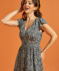Woman wearing a floral dress with pockets and a flattering smocked waist silhouette
