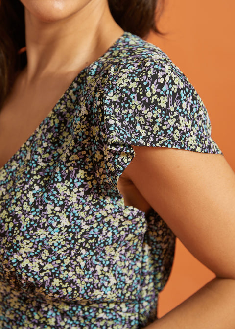 Close-up of flutter sleeve detail on black floral dress